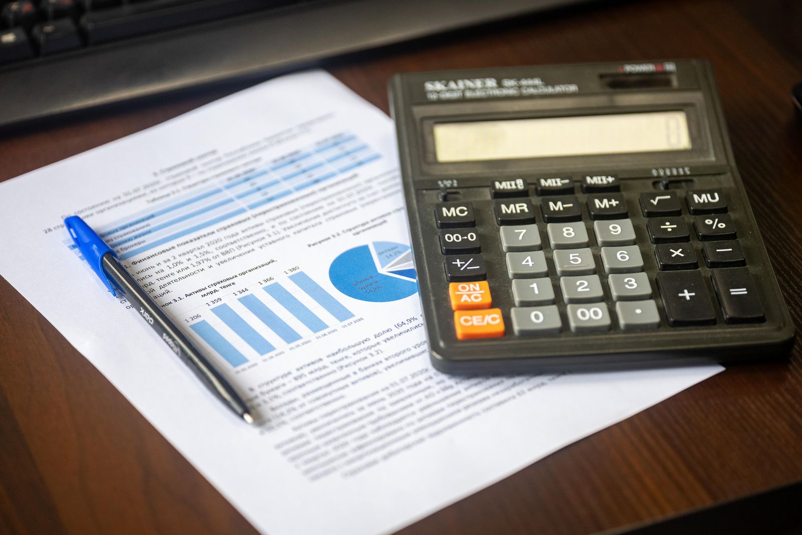 Rapporto finanziario con calcolatrice e penna su un tavolo