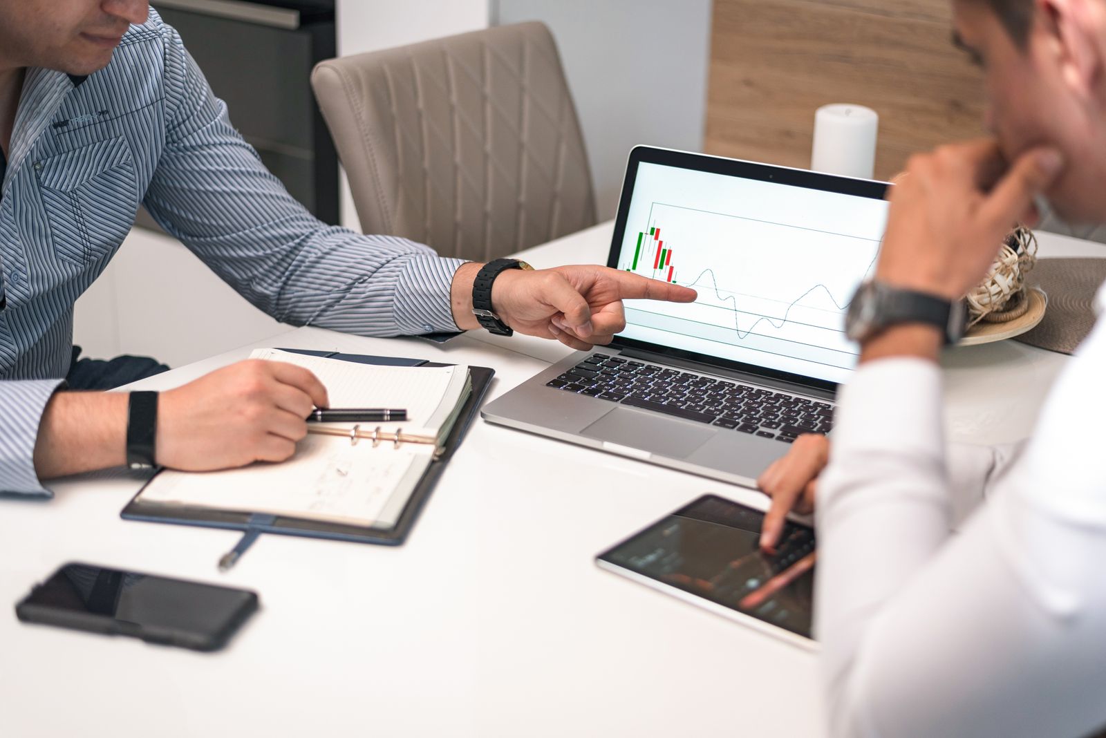 Due professionisti che osservano grafici finanziari su uno schermo